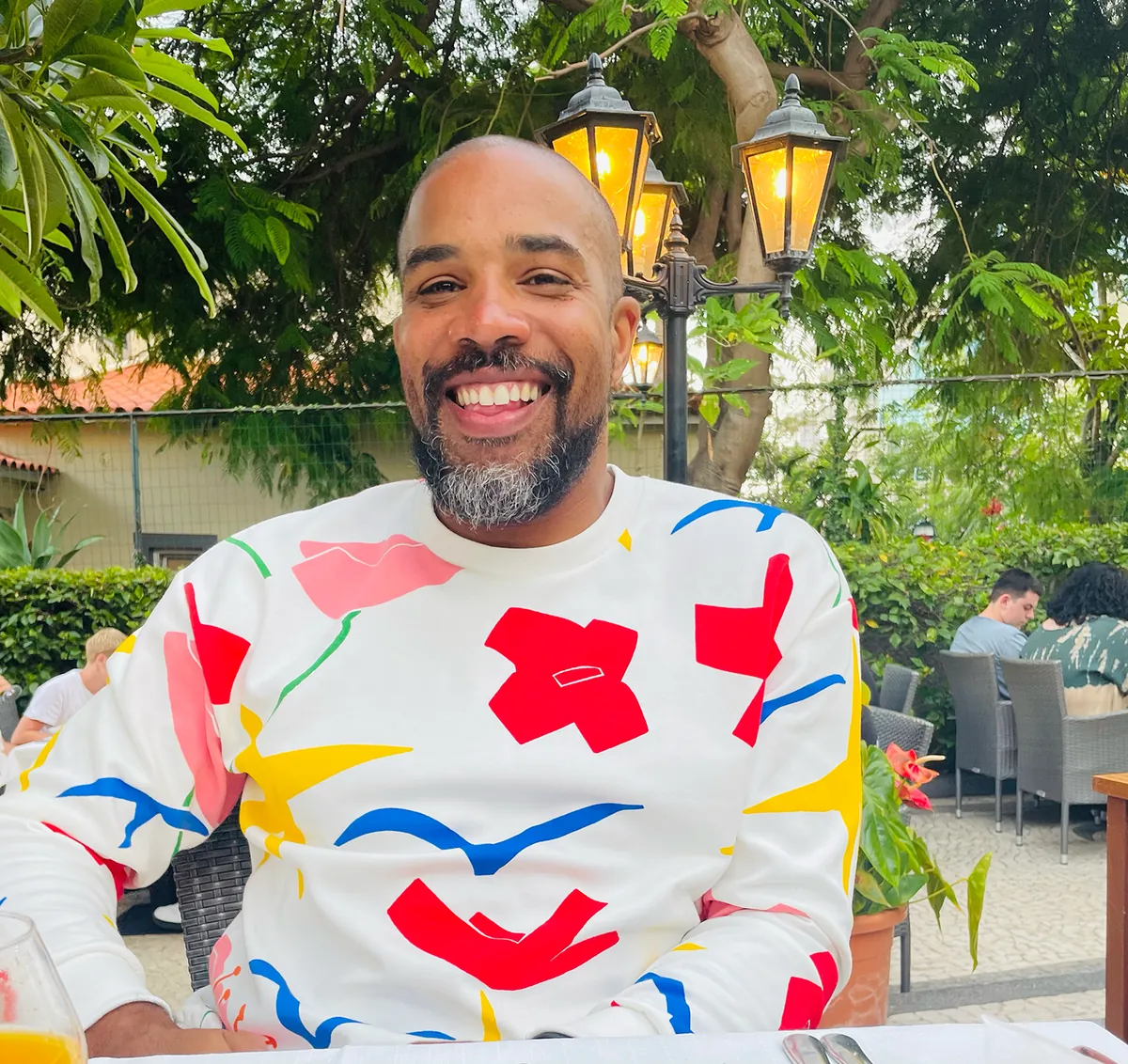 Louie Brown, smiling, in a bright patterned jumper
